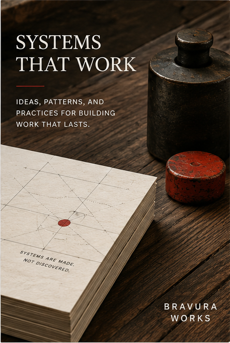 Systems That Work editorial image showing durable workshop weights and a substantial printed volume on a wood surface.